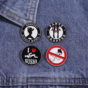 Set of four circular metal pins featuring provocative graphic prints on blue denim fabric