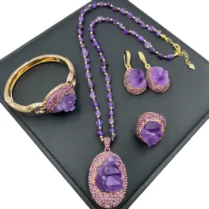 Golden jewelry set with raw amethyst stones including necklace, bracelet, earrings and ring
