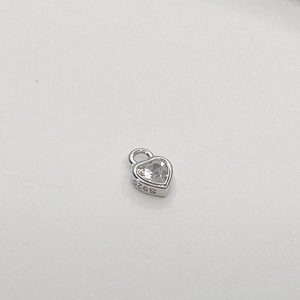 Macro detail of S925 sterling silver heart charm with sparkling cubic zirconia stone