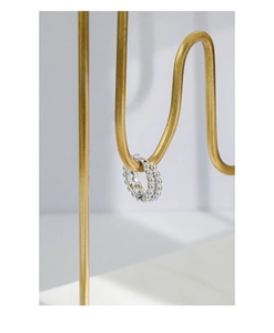 Macro detail of S925 sterling silver beaded hoop earrings on a luxury gold jewelry stand