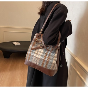 Detailed view of tweed and leather tote bag showing large capacity and shoulder strap