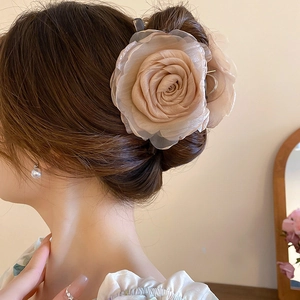 Detail von champagnerfarbenem Organza Blumen Haarklammer an einer eleganten Hochsteckfrisur