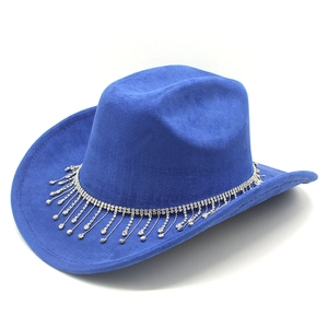 Détail d'un chapeau de cowboy en daim bleu avec franges en strass et pompons argentés