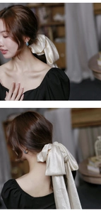 Detailed texture of champagne satin bow hair tie with elegant long hanging ribbons