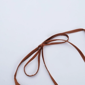 Gros plan sur le détail du nœud marron ajustable et la couture du haut dos nu