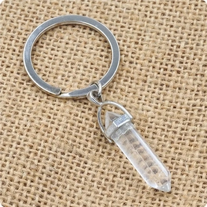 Macro shot of hexagonal clear quartz crystal pendant on rustic linen background