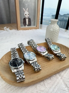 Classic silver metal ladies' watches with multi-color dials on an elegant wooden tray