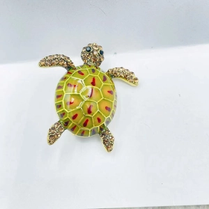 Detailed top view of vintage turtle brooch with green enamel and brown rhinestones