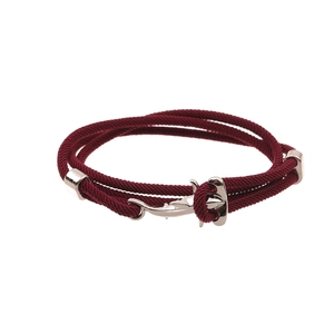 Detail of red rope bracelet featuring a silver anchor-shaped clasp and metal slide buckle