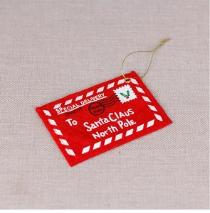Detail of red felt Christmas envelope ornament with gold string and festive printing