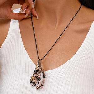 Close-up of vintage ethnic necklace with natural stone beads and tassel details