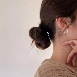 Close-up of minimalist S925 silver wavy twist hoop earrings on a female model ear
