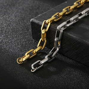 Detail of gold and silver thick geometric chain bracelets with industrial faceted edges