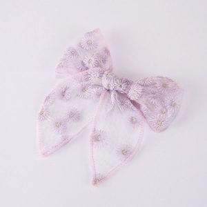 Close-up of a lavender mesh bow hair clip with detailed white daisy embroidery