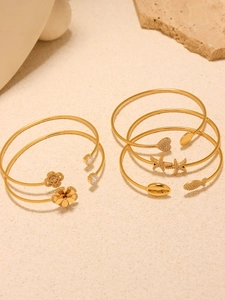 Detailed view of six gold-plated open bangles with starfish and flower zircon charms