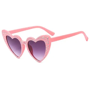 Pink heart-shaped sunglasses with sparkling rhinestones and purple gradient lenses