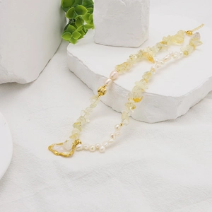 Detail of baroque pearl and citrine beaded necklace with a golden heart pendant