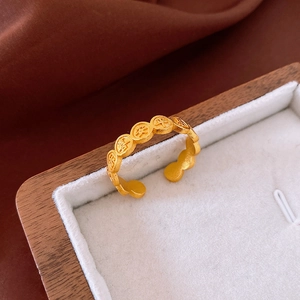 Detail of matte gold adjustable ring with embossed Chinese lucky characters in a jewelry box