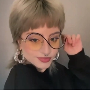 Futuristic gold metal irregular sunglasses with yellow lenses and silver hoop earrings