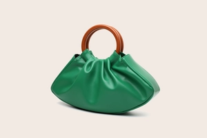 Detail of green pleated PU leather dumpling bag with brown round wooden handle
