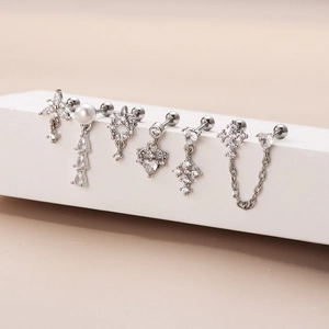 Silver stainless steel stud earrings set with zircon hearts and cross on white pedestals