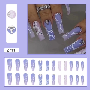 Detail of taro purple long ballet fake nails with 3D white flowers and sparkling rhinestones