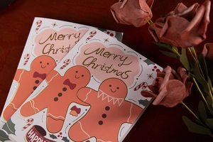 Detail of Christmas cards with gold stamped gingerbread man on a red background