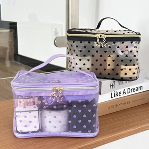 Detail of flocking mesh makeup bags with heart patterns and gold star zippers