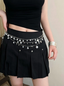 Detail view of double-layer silver waist chain with pearls and star charms on black skirt