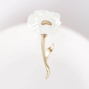 Macro shot of elegant white flower brooch with gold petals and shell-like texture details