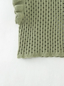Détail d'un haut en maille crochet vert sauge avec volants aux manches et ajouré