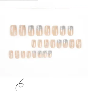 Macro shot of 24pcs glitter press-on nails with star patterns and pink gradient finish