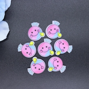 Close-up of seven cartoon candy charms with smile faces in pink and blue gradient colors