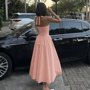 Rückenansicht eines rosa Halterneck-Maxikleids mit rückenfreiem Design und A-Linien-Rock