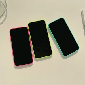 Neon pink, green, and blue silicone phone cases in a minimalist diagonal layout