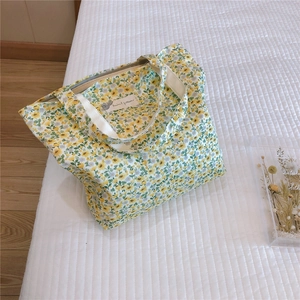 Detail of floral cotton handbag with yellow flowers and secure zipper closure