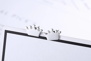 Macro shot of polished silver crown stud earrings with a refined mirror finish detail