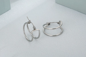Close-up of silver minimalist double-loop earrings with polished metal finish