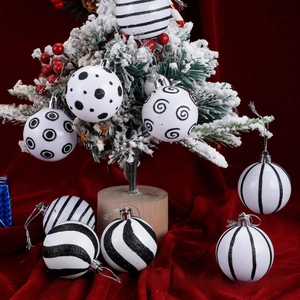 Close-up of white and black Christmas ball ornaments with glitter patterns on a festive tree