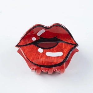 Detalle de la pinza para el pelo con forma de labios rojos brillantes de resina