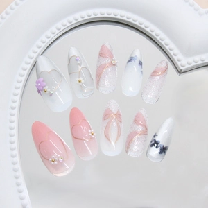 Pink and white cat-eye press-on nails with 3D flowers and pearls, stiletto shape