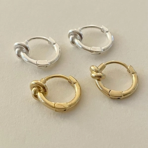 Detailed view of intertwined knot hoop earrings in polished gold and silver finishes