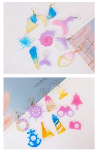 Detail of ocean-themed resin charms featuring seahorse shell and anchor with glitter