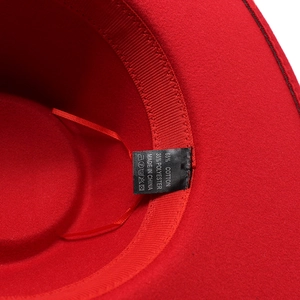 Detail view of red felt hat interior showing 65% cotton fabric label and sweatband