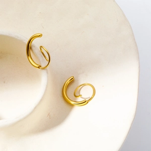Detail view of gold-plated stainless steel spiral earrings with twisted wrap design