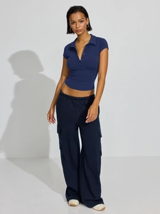 Detail shot of navy short sleeve polo crop top and matching high-waisted cargo pants set