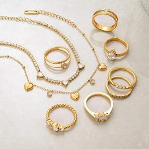 Flat lay of gold plated stainless steel jewelry set with necklaces and zircon rings