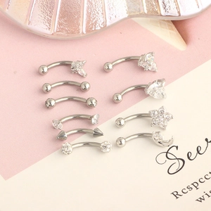Macro shot of stainless steel eyebrow and lip piercings with heart and star charms