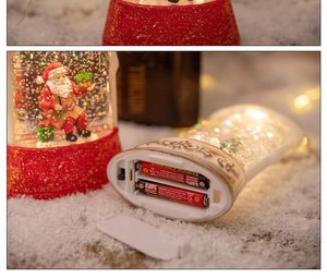 Close-up of the battery compartment and power switch on the Christmas water snow globe