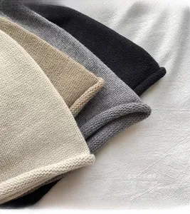 Detailed texture of knitted drawstring beanie hats in beige, khaki, grey and black colors